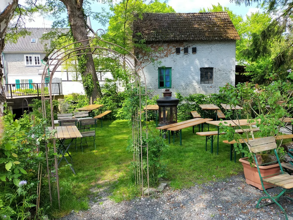 Gartentische im Grünen vor den historischen Häusern in Gruiten