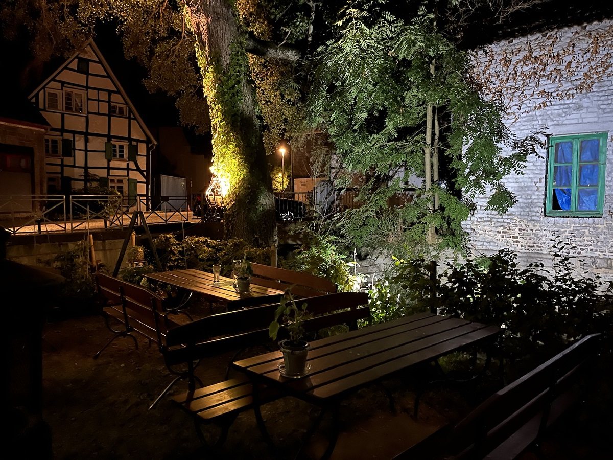 Beleuchteter Garten mit Holzbänken am Abend